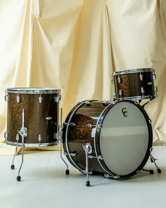 Custom three-piece kit in a dark gold sparkle on a cream backdrop